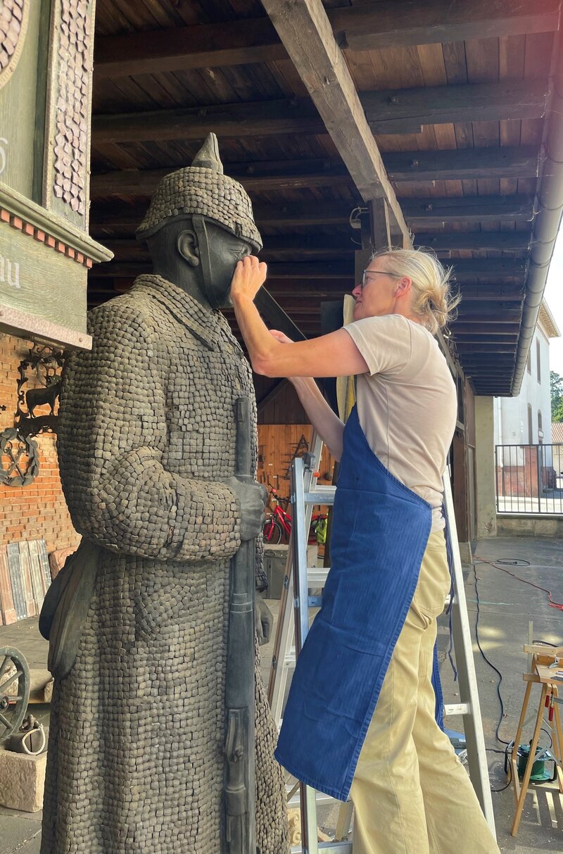 Restauratorin Judith Vogl bei der Arbeit am „Feldgrauen“ im Innenhof des Landauer Stadtmuseums.