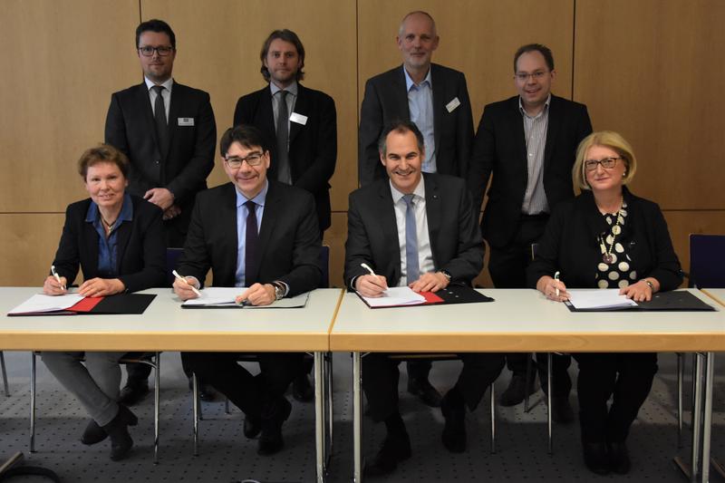 Unterzeichneten die Kooperationsvereinbarung zum Patientenorientierten Case Management (sitzend v.l.n.r.): Karin Leiner (&Ouml;kumenische Sozialstation Landau), Oberb&uuml;rgermeister Thomas Hirsch (Stadt Landau), Landrat Dietmar Seefeldt (Landkreis S&uuml;dliche Weinst