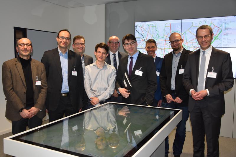 Oberb&uuml;rgermeister Thomas Hirsch (4.v.r.) und Verkehrsdezernent Dr. Maximilian Ingenthron (r.) haben sich jetzt gemeinsam mit Mitarbeitern der Verwaltung bei den Fachleuten des Karlsruher Software-Unternehmens PTV Group &uuml;ber die Errichtung eines intelligen